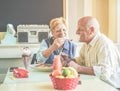 Happy senior couple having fun eating pancakes during united states vacation - Mature people enjoying brunch at bar restaurant - Royalty Free Stock Photo