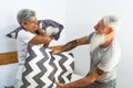 Happy senior couple having fun fighting with pillows in bed Royalty Free Stock Photo