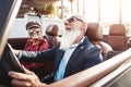 Happy senior couple having fun on new convertible car - Mature people enjoying time together during road trip vacation Royalty Free Stock Photo