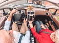 Happy senior couple having fun on new convertible car - Mature people enjoying time together during road trip vacation Royalty Free Stock Photo