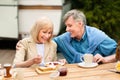 Happy senior couple having toasts with jam and coffee for breakfast at campground Royalty Free Stock Photo