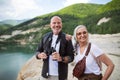 Happy senior couple on hiking trip on summer holiday, using binoculars. Royalty Free Stock Photo