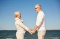 Happy senior couple holding hands summer beach Royalty Free Stock Photo