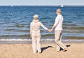 Happy senior couple holding hands summer beach Royalty Free Stock Photo