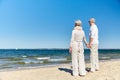 Happy senior couple holding hands summer beach Royalty Free Stock Photo