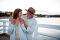 Happy senior couple hugging outdoors on pier by sea, looking at each other. Royalty Free Stock Photo