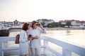 Happy senior couple hugging outdoors on pier by sea, looking at view through binoculars. Royalty Free Stock Photo