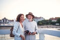 Happy senior couple hugging outdoors on pier by sea, smiling. Royalty Free Stock Photo