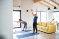 A senior couple indoors at home, doing exercise in living room. Royalty Free Stock Photo