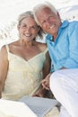 Happy Senior Couple with Laptop Computer on Beach Royalty Free Stock Photo