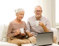 Happy senior couple with laptop and cups at home Royalty Free Stock Photo