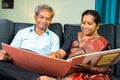 Happy senior couple laughing by looking into to marriage photo album - concept of old memories, nostalgic and family Royalty Free Stock Photo