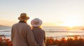 Happy senior couple looking enjoying beach sunset landscape together, summer vacation at sea coast Royalty Free Stock Photo