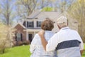 Happy Senior Couple Looking at Front of House Royalty Free Stock Photo