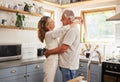 Happy senior couple, love and care embracing relationship bonding together in the kitchen at home. Elderly man and woman Royalty Free Stock Photo