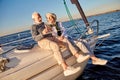 Happy senior couple in love drinking wine or champagne and laughing while celebrating wedding anniversary on a sailboat
