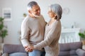 Happy senior couple in love looking at each other with tenderness, dancing together in living room Royalty Free Stock Photo