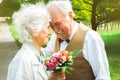 Happy senior couple love story. Old couple is walking in the green park. Grandmother and grandfather laughing. Elderly people Royalty Free Stock Photo