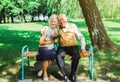 Happy senior couple love story. Old couple is walking in the green park. Grandmother and grandfather laughing. Elderly people Royalty Free Stock Photo