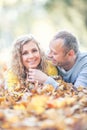 Happy senior couple lying in autumn maple leaves Royalty Free Stock Photo