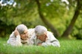 Happy senior couple lying on green grass in summer park Royalty Free Stock Photo