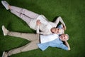 Happy senior couple lying together on green grass and smiling at camera Royalty Free Stock Photo