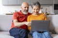 Happy Senior Couple Making Online Purchases While Relaxing With Laptop At Home Royalty Free Stock Photo