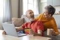Happy Senior Couple Making Online Shopping While Relaxing With Laptop At Home Royalty Free Stock Photo