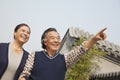 Happy senior couple outdoors pointing by traditional building in Beijing Royalty Free Stock Photo