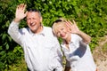 Happy senior couple outdoors waving hands Royalty Free Stock Photo