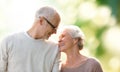 Happy senior couple over green natural background