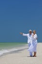 Happy Senior Couple Pointing To Sea on Beach Royalty Free Stock Photo