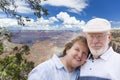 Happy Senior Couple Posing on Edge of The Grand Canyon Royalty Free Stock Photo