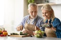 Happy Senior Couple Preparing Tasty Lunch Together In Kitchen, Royalty Free Stock Photo