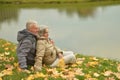 Happy senior couple relaxing in park with autumn leaves Royalty Free Stock Photo