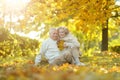 Happy senior couple relaxing in park with autumn leaves Royalty Free Stock Photo