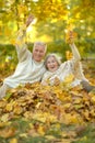 Happy senior couple relaxing in park with autumn leaves Royalty Free Stock Photo