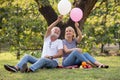 Happy senior couple relaxing in park playing balloons together . old people sitting on grass in the summer park . Elderly resting