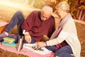 Happy senior couple relaxing in park playing chess together Royalty Free Stock Photo