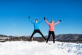 Happy senior couple runners jumping in winter nature.