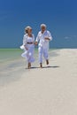 Happy Senior Couple Running on A Tropical Beach Royalty Free Stock Photo