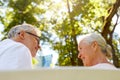 Happy senior couple sitting on bench at park Royalty Free Stock Photo