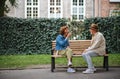 Happy senior couple sitting on bench and playing chess outdoors in park. Royalty Free Stock Photo