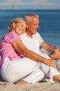 Happy Senior Couple Sitting Laughing Smiling on a Beach Royalty Free Stock Photo