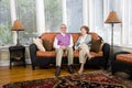 Happy senior couple sitting on living room couch Royalty Free Stock Photo