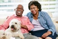 Happy Senior Couple Sitting On Sofa With Dog Royalty Free Stock Photo