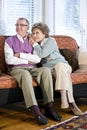 Happy senior couple sitting together on couch Royalty Free Stock Photo