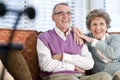 Happy senior couple sitting together on couch Royalty Free Stock Photo