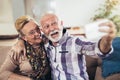 Happy senior couple sitting together on a sofa in their living room Royalty Free Stock Photo