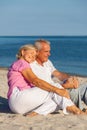 Happy Senior Couple Sitting Together on a Tropical Beach Royalty Free Stock Photo